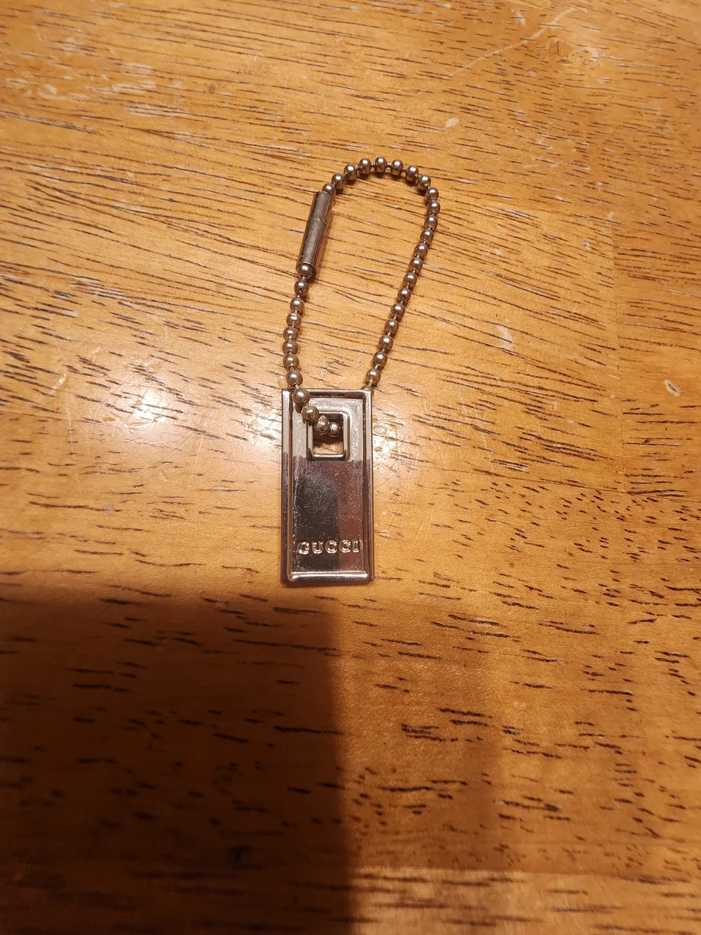Gucci Sterling Silver Logo Tag likely used on a bracelet or keychain